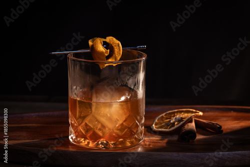 Εκτύπωση καμβά Smoked whiskey cocktail served on the rocks garnished with a dehydrated orange slice and a cherry with dramatic lighting served on a wooden surface