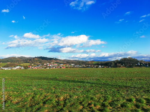 Green field and rural village by blue sky in winter Slovakia