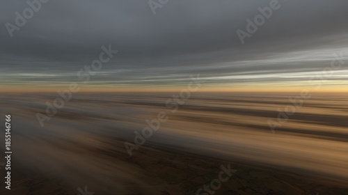 Horizon line stretches across a blurred, dynamic sky and landscape during twilight hours