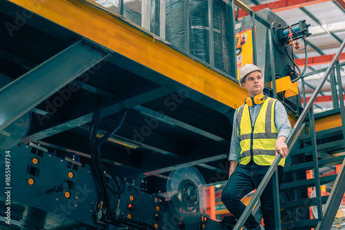 Fotografia Caucasian industrial engineer man wear safety helmet vest walking down metal stairs in factory