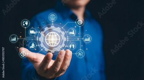 Global logistics and industrial management concept with hand holding gear mechanism,world globe icon to control supply chain system,international trade and distribution network.