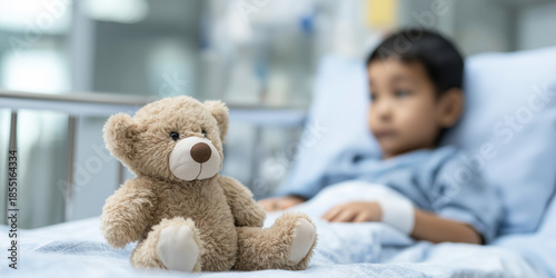 Teddy bear sitting on a bed in a hospital room, providing comfort to a sick child receiving medical care