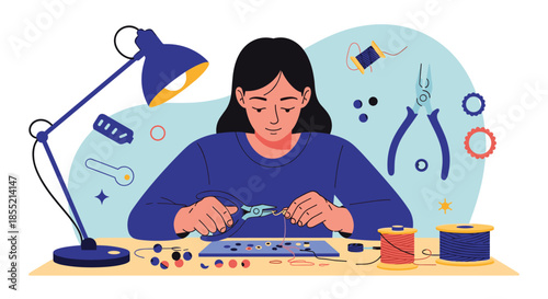 Creative young woman sitting at her organized workspace focused on making handmade jewelry with various craft tools and beads.
