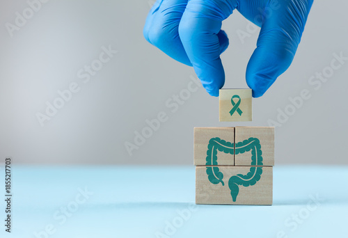 фотографія A doctor's hand arranges wooden cubes with a colon icon