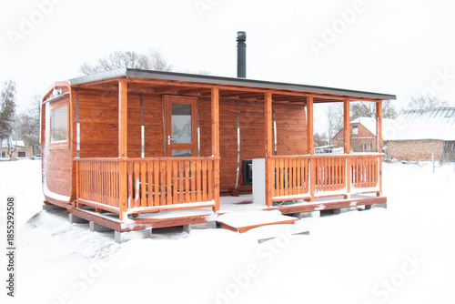 new house made of wood, eco house in nature on a winter day. snow-covered fluffy spruce trees, walks through the winter white forest.