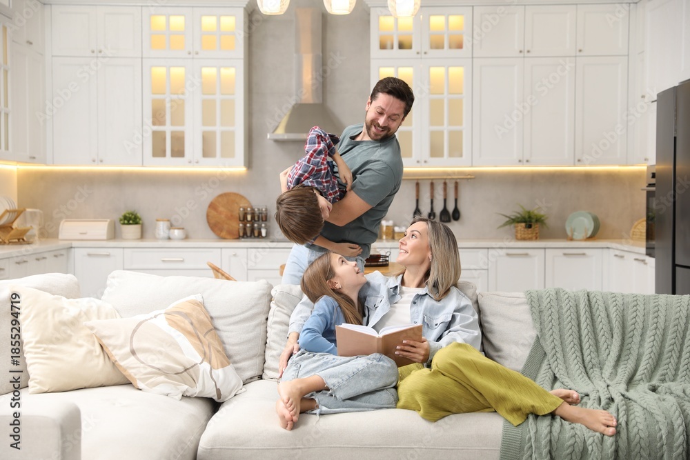© New Africa - Happy family reading book and spending time together on sofa in kitchen at home © New Africa - Happy family reading book and spending time together on sofa in kitchen at home