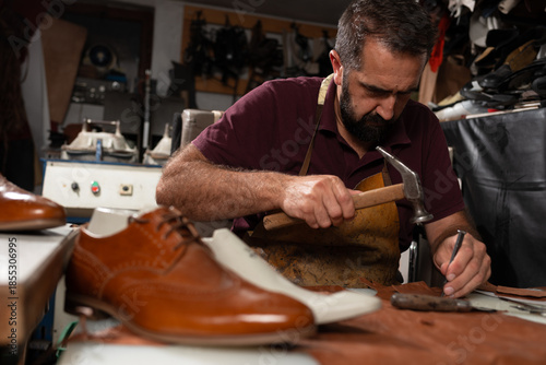 Foto Shoemaker at work crafting leather shoes with hammer and chisel in a traditional