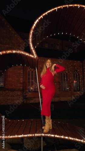 Elegant woman in vibrant attire, Fashionable female strikes bold position amidst urban illumination slow motion