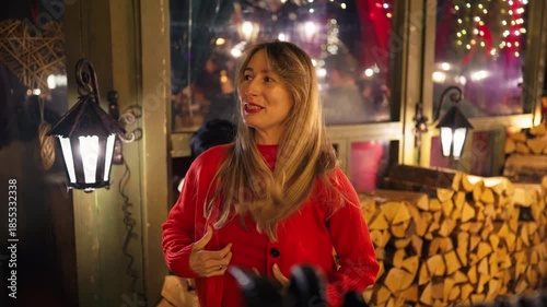 Pregnant woman in red celebrating outdoors, Expectant woman in red at lively night market celebration slow motion