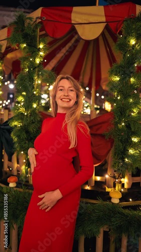 Woman in red showing joy, Expectant mother dressed in red smiling gently with warm ambient lighting slow motion