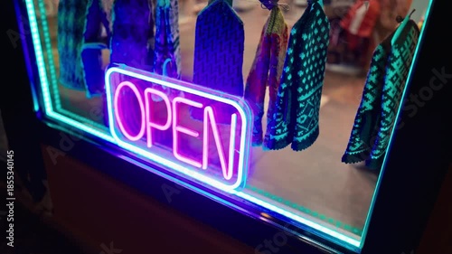 City shop neon, Vibrant city shop features radiant neon signage as worker carefully organizes products slow motion
