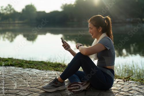 Photos Sport young woman using mobile and looking at smartwatch on her wrist, tracking