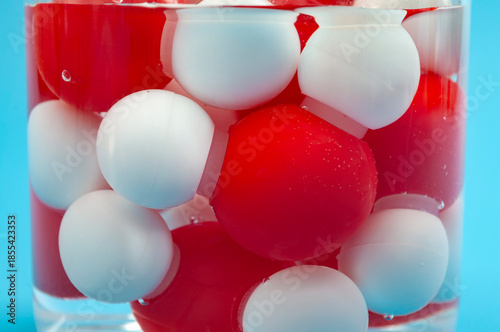 Water Molecule Model Concept with H2O Chemistry Atom Link Toy in Beaker of Water on Blue Background