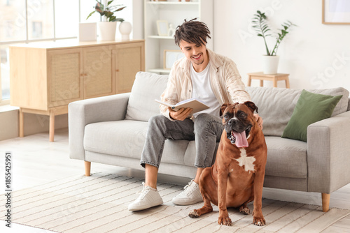 Young man with Boxer dog re...