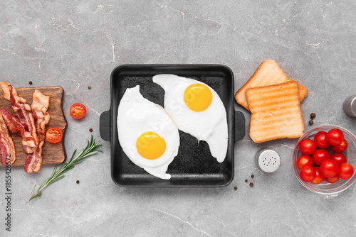 Fried eggs in black pan wit...
