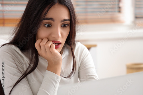 Scared young woman using la...