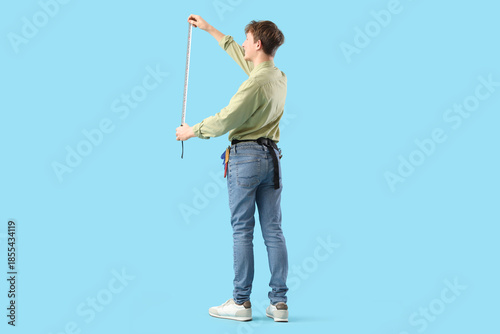 Young man measuring somethi...