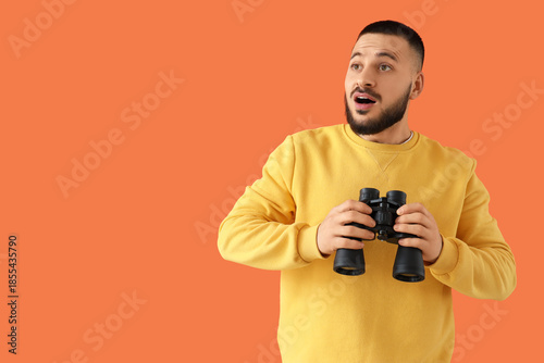 Shocked young man with bino...