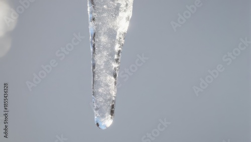 Close-up of a Melting Icicle Against a Gray Background.