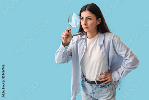 Young woman with magnifier ...