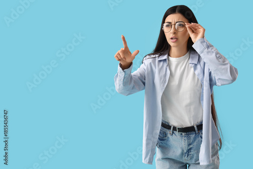 Young woman pointing at som...