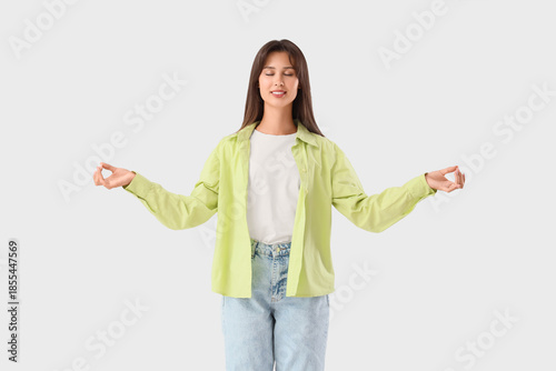 Young woman meditating on white background