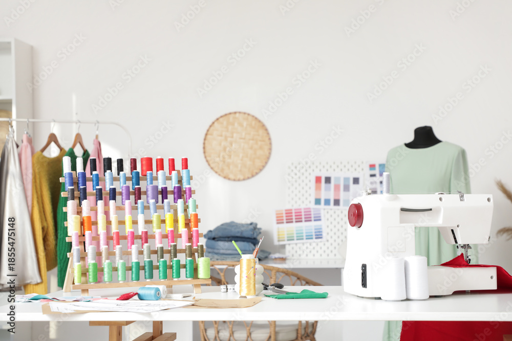 © Pixel-Shot - Tailor's workplace with sewing machine and thread spools in workshop