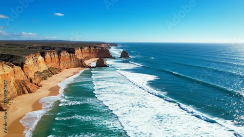 Aerial View Ocean Waves Crashing on Sandy Beach and Cliffs on Sunny Day