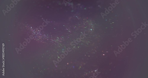 Shimmering flow. Defocused glitter texture. Shiny haze stream ink blend sparks. Colorful water swirl abstract purple green background.