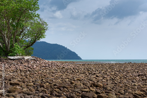 Rocks/stones on the  beach during a daylight on the islands, Thailand.Background image of the beach with sea in the distance with pebble stones.