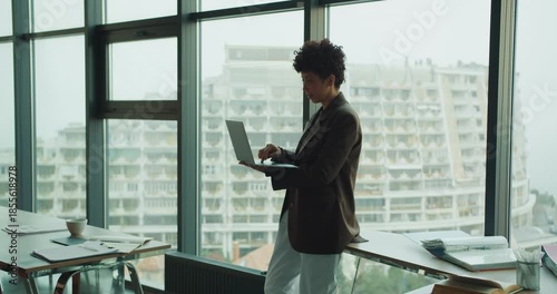 Innovator focusing on city view beyond expansive glass window