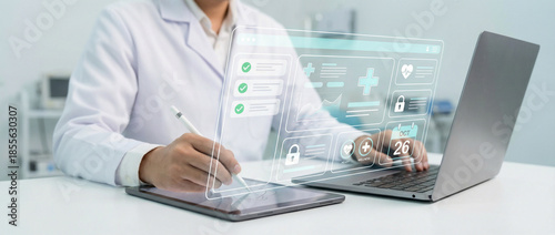 Doctor Managing Electronic Medical Records and Patient Dashboard on Digital Tablet and Laptop