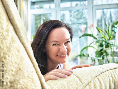 Bright interior setting with woman enjoying her time at home among plants and natural light