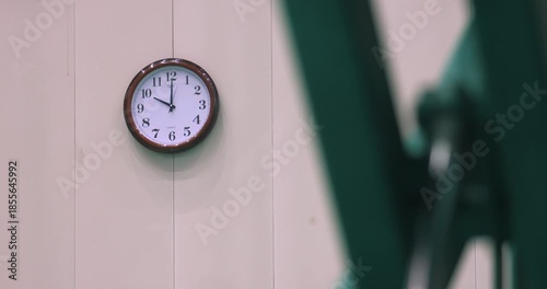 Wall Clock Showing 9 o'Clock with Blurred Figure in Office