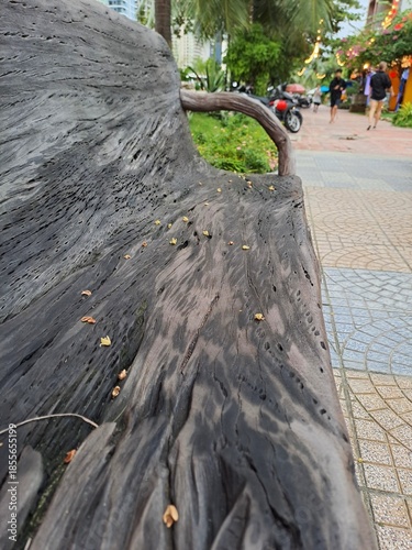 Artistic wooden seating with natural branch armrests located in a landscaped park area