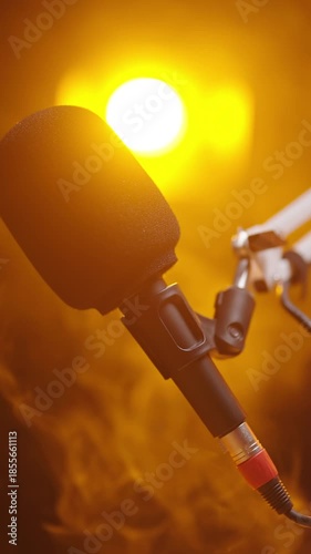 Microphone in focus with strong orange backlight on black background
