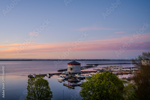 Round stone martello tower by marina at sunset