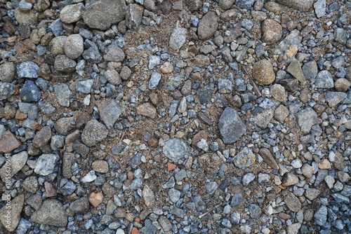 Top view of scattered river stones on dry ground.