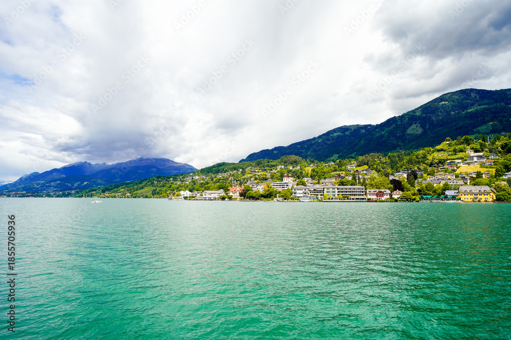 Fototapeta premium View of Lake Millstatt and the surrounding green landscape. Idyllic nature by the lake north of the Drava Valley near the town of Spittal an der Drau in Carinthia. 