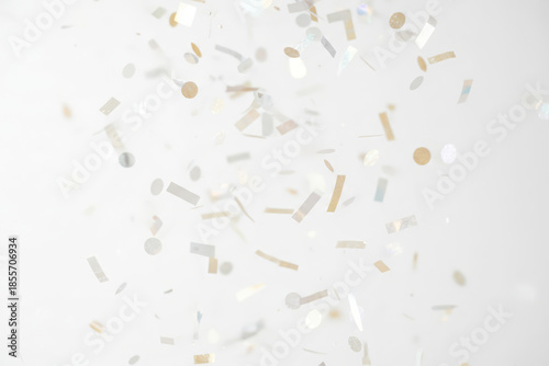 Elegant white background with falling gold and silver confetti, festive minimal celebration concept for holidays, parties, luxury events, weddings, New Year, birthdays, and modern abstract design