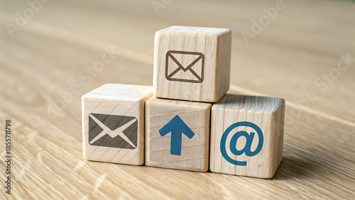 Wooden Blocks with Communication Icons: Email, Arrow Up, and At Symbol Stacked on Table