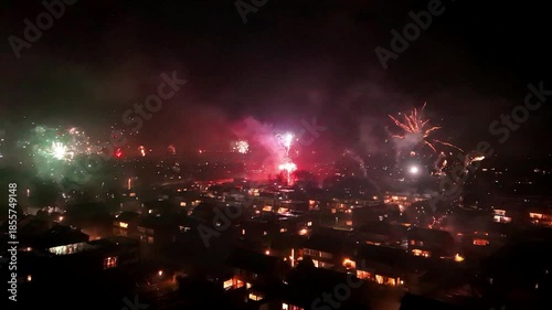 Wallpaper Mural Wide view of New Year’s Eve fireworks lighting up a residential neighborhood in the Netherlands at night. Festive atmosphere, urban skyline, celebration moment, winter holiday scene. Torontodigital.ca