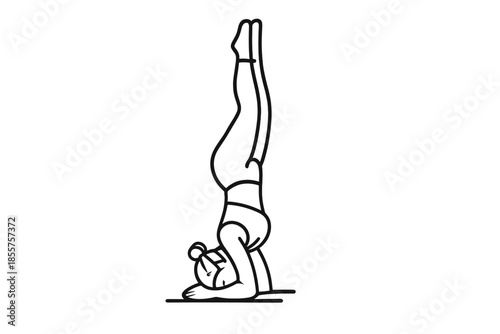 Woman in a yoga handstand against a gray background.