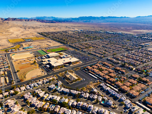Aerial view of Los Angeles suburban neighborhoods bordering desert landscape, with distant mountains and expanding residential development