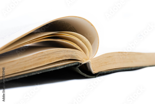 Opened book with hard cover, focus on the aged, yellow pages isolated on white background.