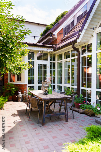 Garden dining area in sunny weather with green plants