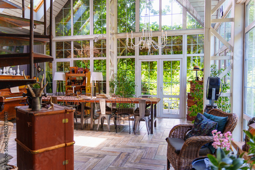 Dining area with large windows and plants in the background