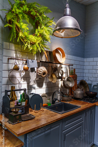 A kitchen features pots and utensils hanging on a wall