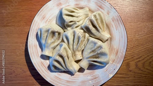 CloseUp Dumpling On Ceramic Plate, Textured Folds And Seasoning Visible, Pepper Specks And Soft Light Emphasize Pleats And Dough, Intimate Foodie Angle Ideal For Recipe Or Blog Content,