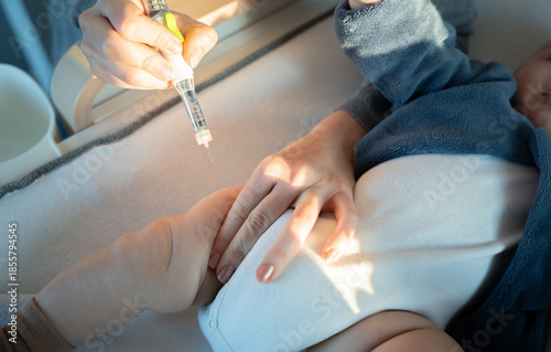 Cuadro en lienzo Close-up of a mother injecting insulin into her baby thigh for diabetes care